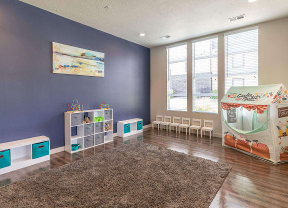 a playroom with a play table and chairs and a large window