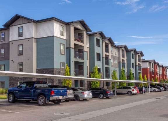 a row of apartment buildings with cars parked in front of them