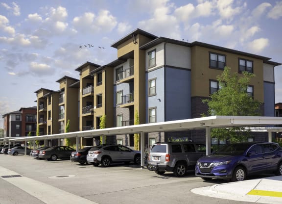 a rendering of an apartment building with cars parked in front of it