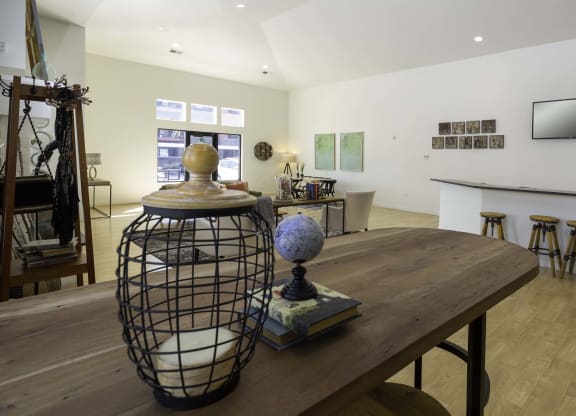 a large room with a wooden table and a black cage with a globe on top of it