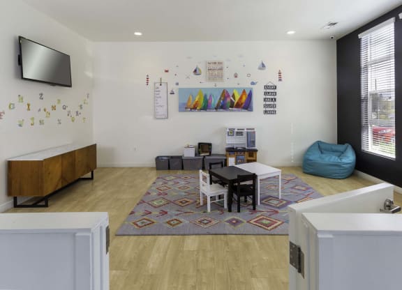 a room with a table and chairs and a flat screen tv on the wall
