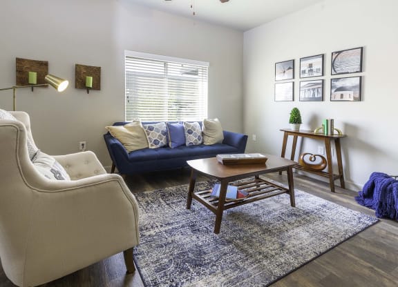 a living room with a blue couch and two white chairs