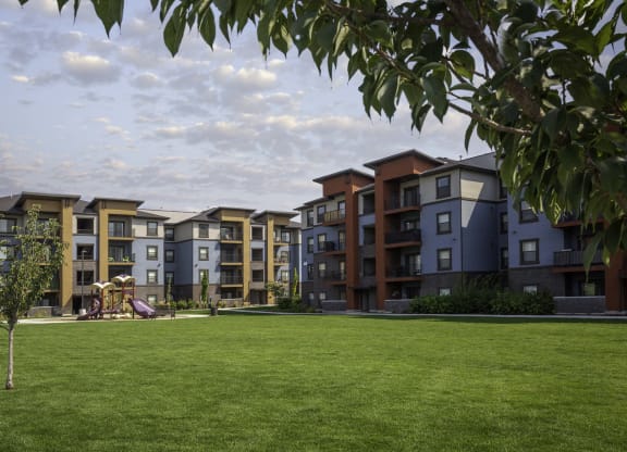 picture of an apartment building with a playground in the foreground