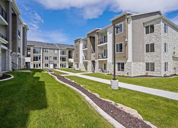 Apartment complex with a grassy area in front.