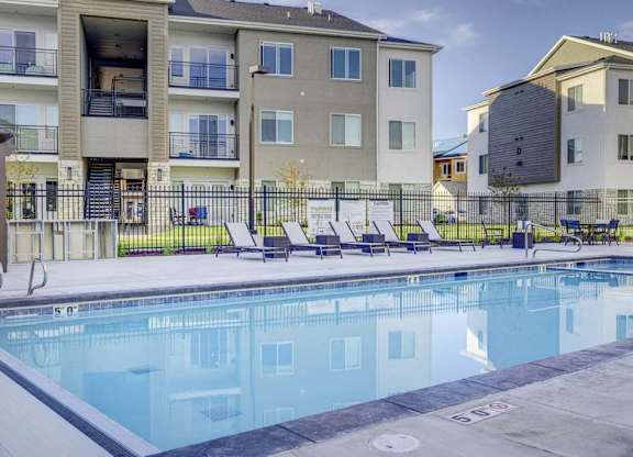 A swimming pool in front of apartment buildings.