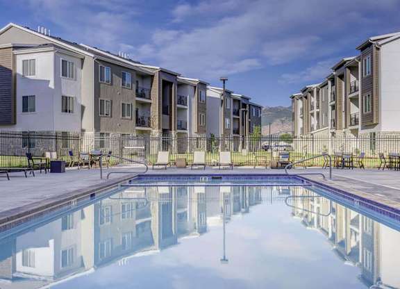 A swimming pool in front of apartment buildings.