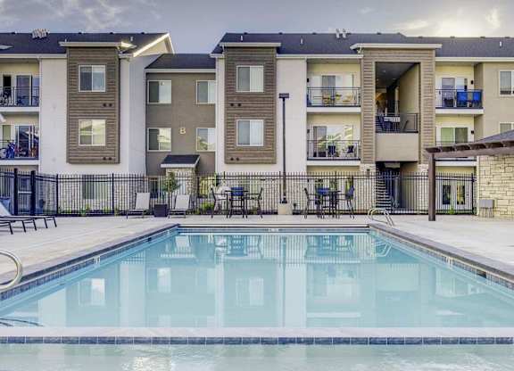 A swimming pool in front of apartment buildings.