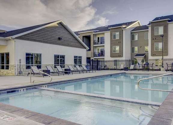 A swimming pool in front of apartment buildings.