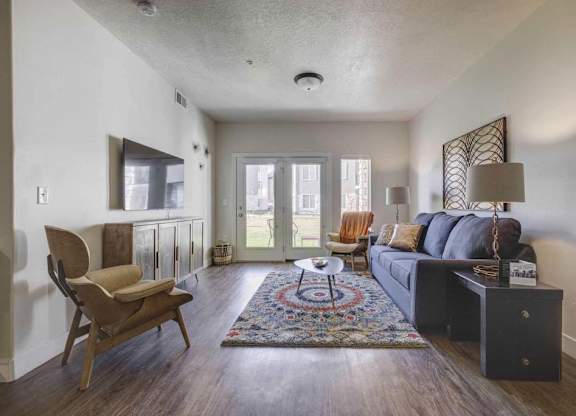 A living room with a couch, chair, and rug.