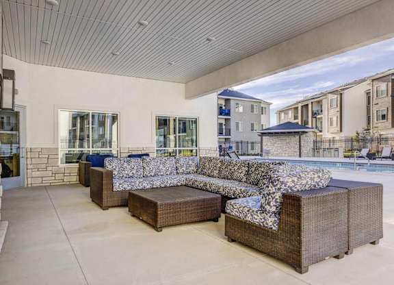 A modern outdoor seating area with a large couch and a coffee table.