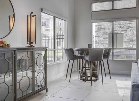 A modern living room with a glass table and chairs.