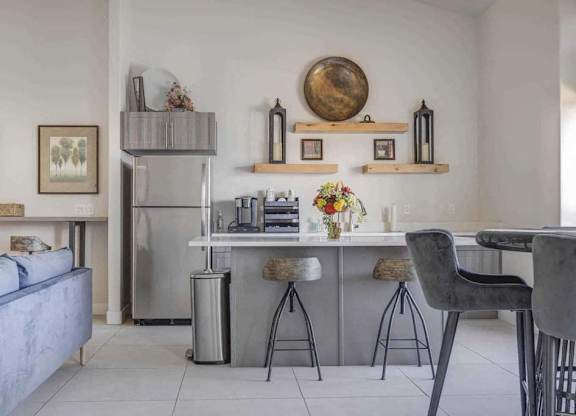 A modern kitchen with a blue sofa and a grey chair.