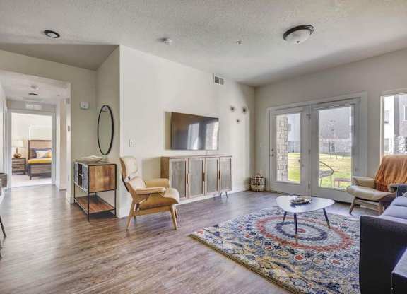 A living room with a rug and a chair.