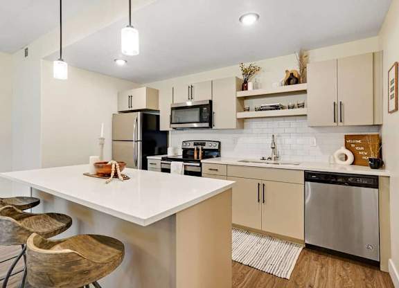 A kitchen with a white countertop and stainless steel appliances.