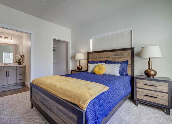 A bedroom with a bed, nightstands, and a mirror.