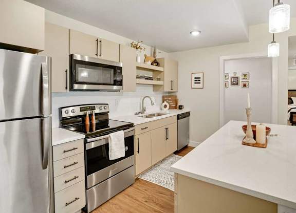 A modern kitchen with stainless steel appliances and a white countertop.