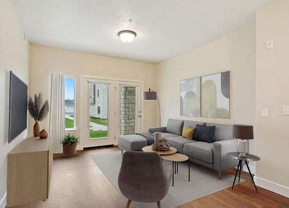 A living room with a grey couch, a brown cabinet, and a television.