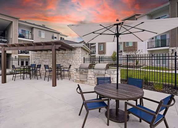 A patio with a table and chairs is set up outside a building.