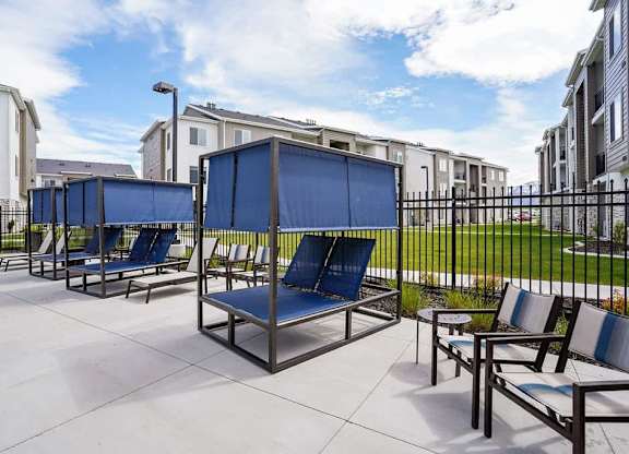 A row of blue sun loungers are on a patio.