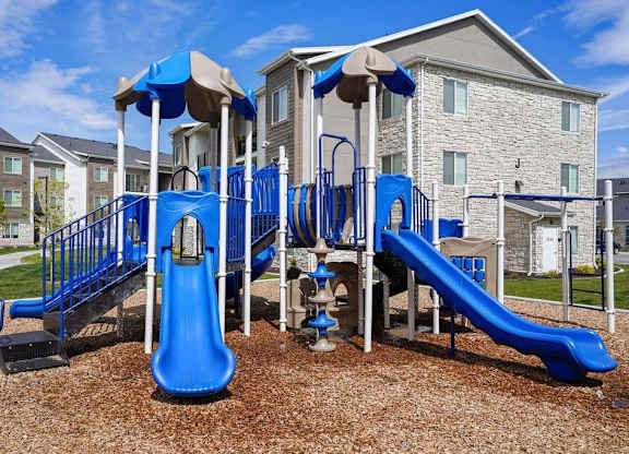 A playground with a blue slide and a brown slide.