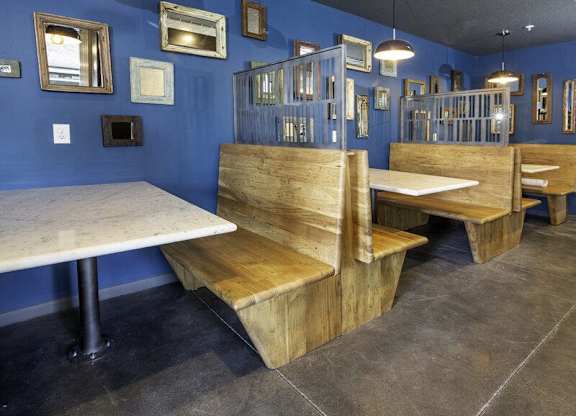A blue room with wooden benches and tables.
