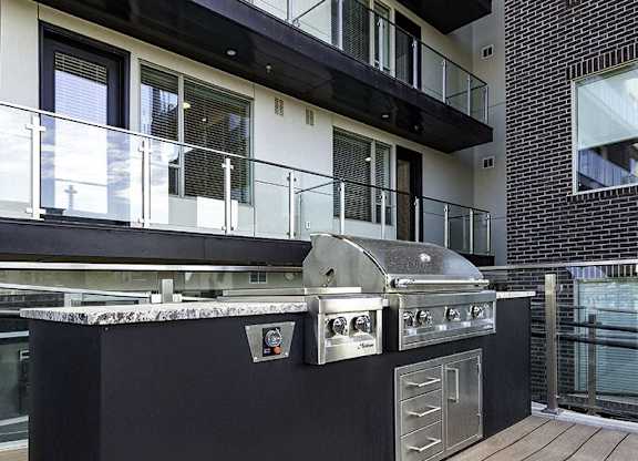 A modern outdoor kitchen with a grill and sink.