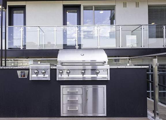 A modern outdoor kitchen with a grill and oven.