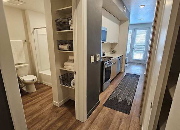 A small bathroom with a toilet, sink, and a walk-in closet.