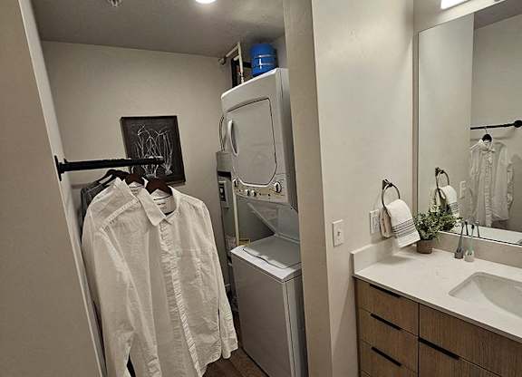 A white shirt hanging on a rack in a bathroom.