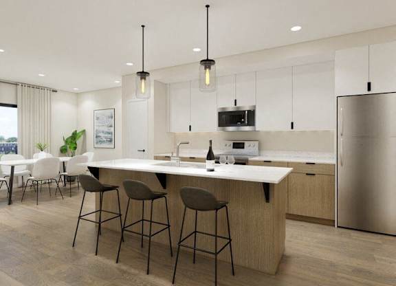 A modern kitchen with a large island and bar stools.
