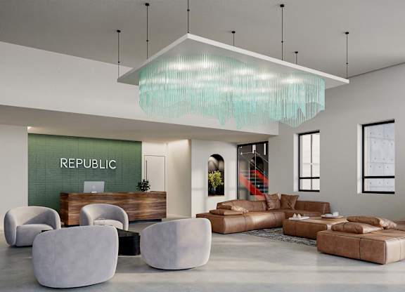 A modern living room with a large sofa, armchairs, and a glass chandelier.
