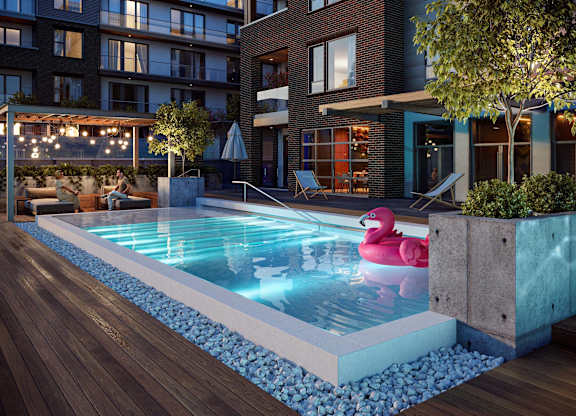 A pool with a pink flamingo float in the middle of it.