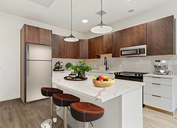 A kitchen with a white countertop and brown bar stools.