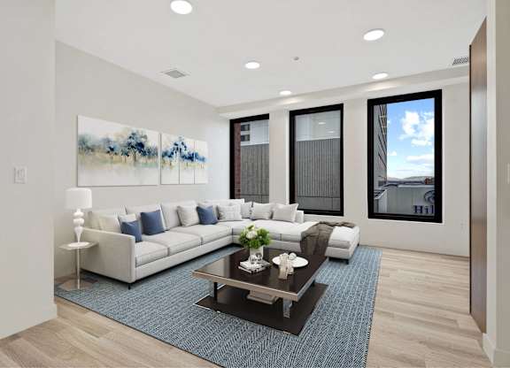 A modern living room with a large painting on the wall and a view of the city.