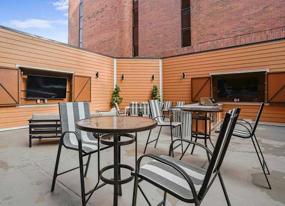 A patio with a table and chairs and a television.
