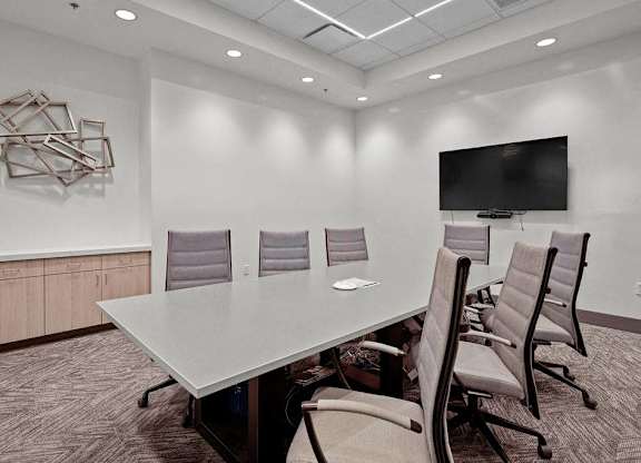 A conference room with a large table and chairs.