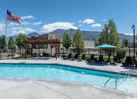 A pool with a mountain in the background and a flag on a pole.