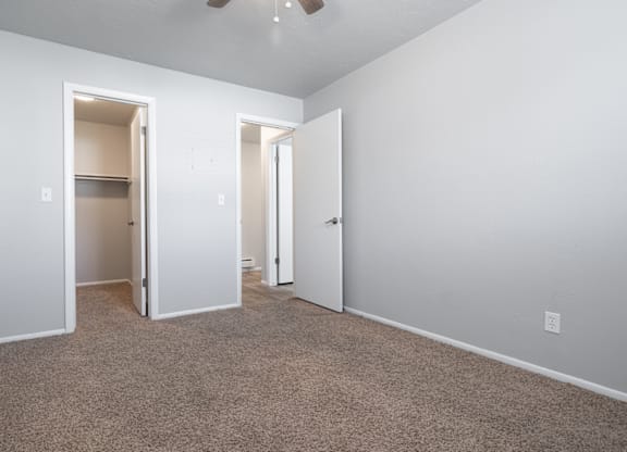 A room with carpeted floor and two open doors.