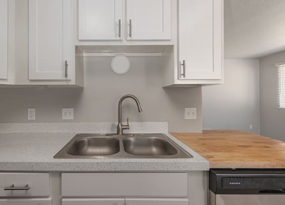 A kitchen with a sink and a stove top oven.
