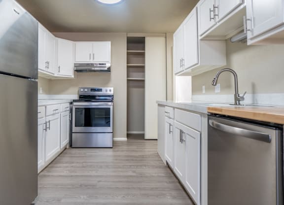 A modern kitchen with stainless steel appliances and white cabinets.