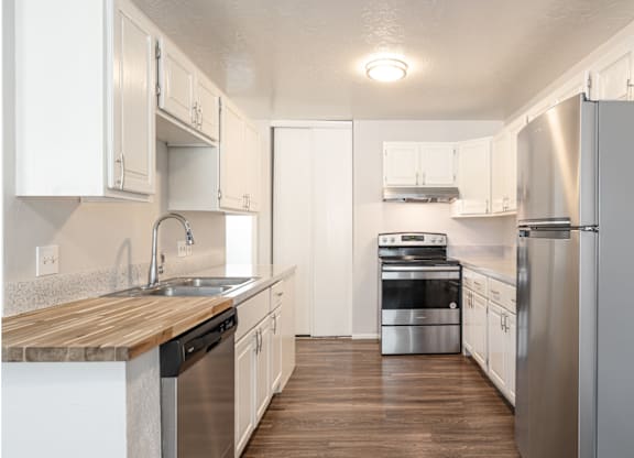 A kitchen with white cabinets and stainless steel appliances.