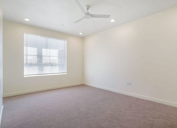 an empty bedroom with a large window