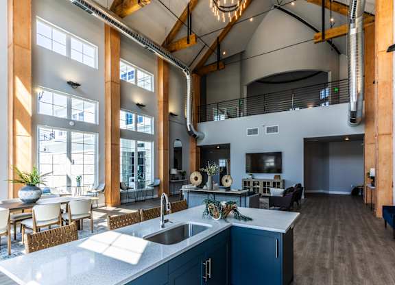 A modern kitchen with a large island and a dining area.