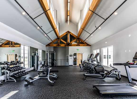 A gym with treadmills, weights, and exercise equipment.