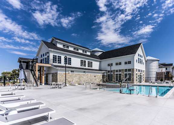 A large white building with a pool in front.