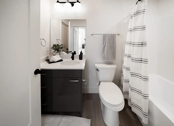 A white toilet sits next to a white sink in a small bathroom.