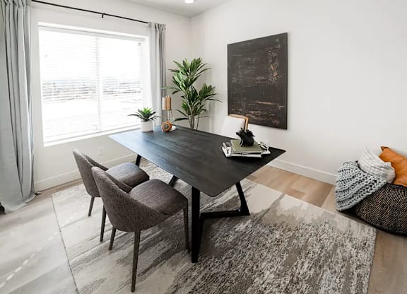 A modern dining room with a large table and chairs.