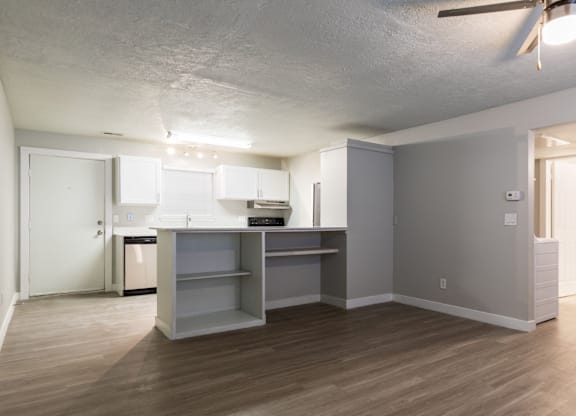 A kitchen with a white counter top and a white fridge.