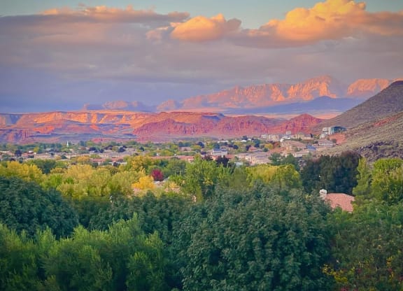 a city with mountains in the background and trees in the foreground