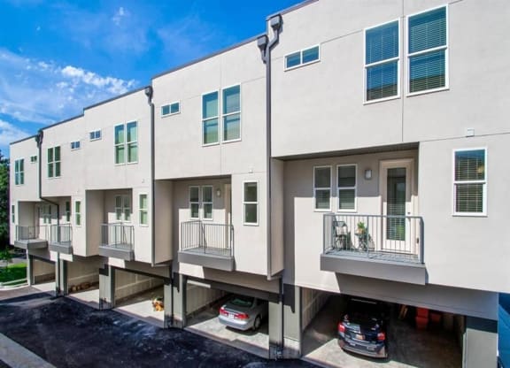 a row of apartment buildings with cars parked in front of them  at Aero Luxury Townhomes in Layton, Utah